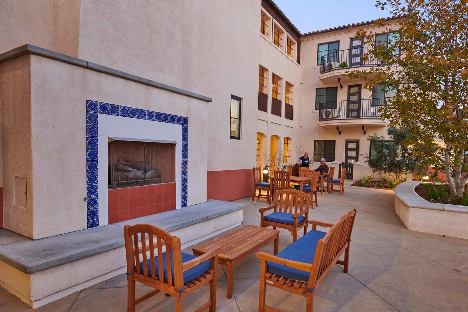 a patio with chairs and a fire place.