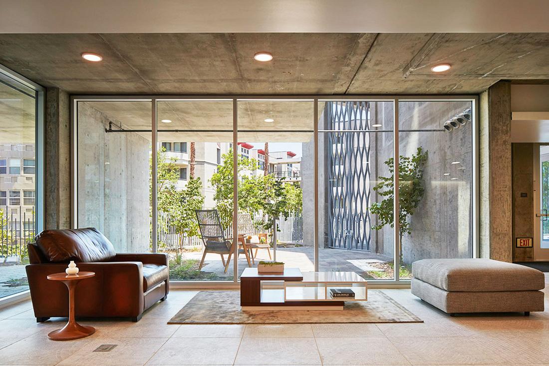 a living room filled with furniture and large windows.