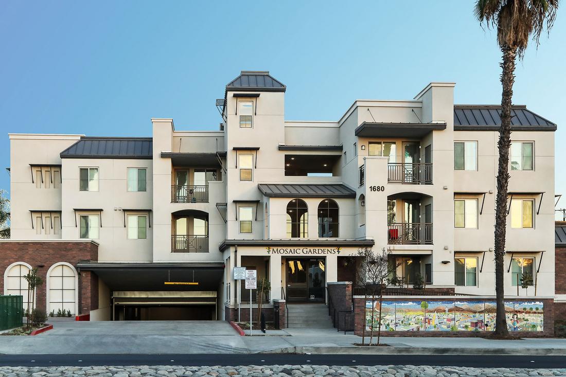 an apartment building with a parking lot in front of it.